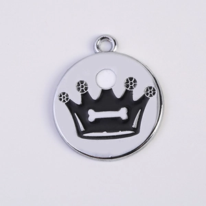 Close-up of a silver pet ID tag with a black crown and bone icon on white enamel