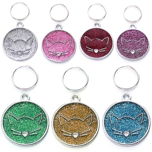 Macro detail of round glitter pet ID tags in seven colors with cat face engraving