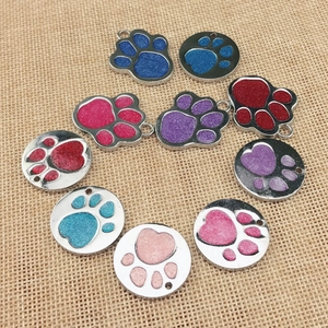 Detail view of colorful paw print pet ID tags with sparkling glitter enamel finish