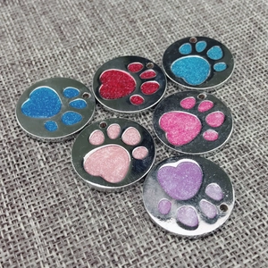 Close-up of colorful round alloy pet tags with heart paw print glitter designs