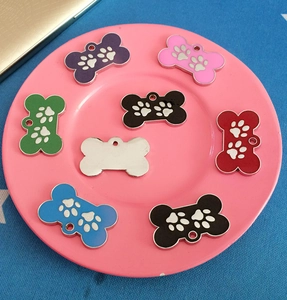 Bone-shaped metal pet ID tags with white paw prints in assorted vibrant colors