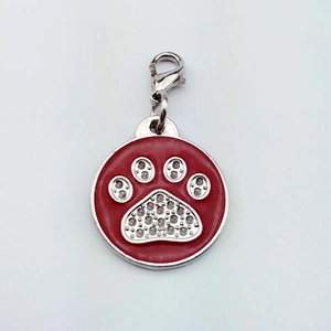 Détail macro du médaillon rouge pour animal avec patte argentée et strass brillants