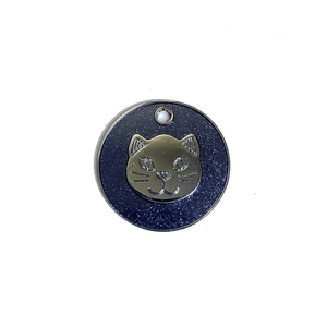 Detailed close-up of a round blue glitter pet ID tag featuring a metallic cat face icon