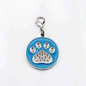 Détail du pendentif patte en émail bleu avec strass et fermoir mousqueton en métal