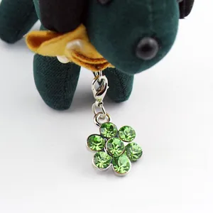 Detail of flower-shaped pet collar pendant with green rhinestones and silver lobster clasp