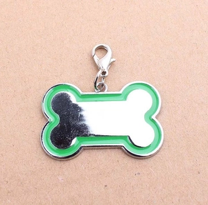 Close-up of a bone-shaped pet tag with green enamel border and silver lobster clasp