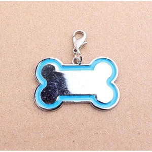 Macro detail of a bone-shaped pet ID tag with blue enamel edge and polished metal center