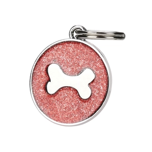 Macro detail of a round red glitter pet ID tag with a silver metal bone centerpiece