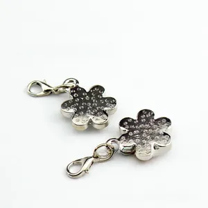 Macro shot of silver plum blossom flower charms with rhinestones and lobster clasps