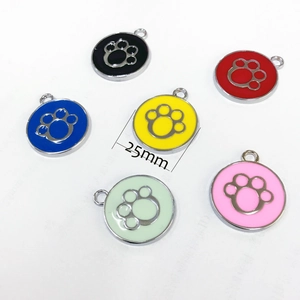 Flat lay detail showing six colors of 25mm zinc alloy pet ID tags with cutout paw prints