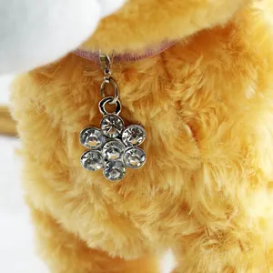 Macro detail of plum blossom petal pendant featuring seven sparkling inset crystals