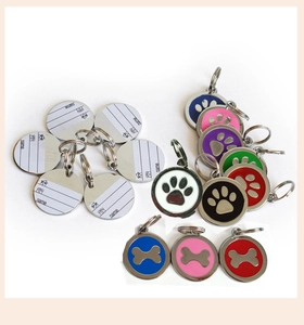 Detail of round pet ID tags with paw prints and reverse side for contact info