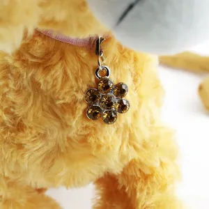 Close-up of plum blossom pet pendant with brown crystals and pink ribbon tie