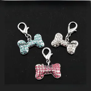 Detail of bone-shaped pet pendants with sparkling crystals and silver lobster clasps