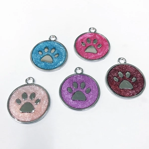 Five colorful glitter paw print charms for pet collars on a clean white background