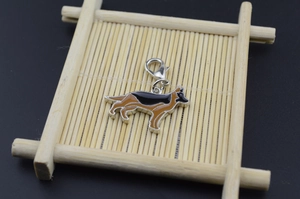 Enamel German Shepherd pet charm with silver lobster clasp on a bamboo stand
