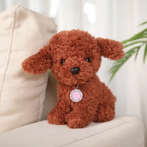 Gros plan d'une médaille rose pour chien avec gravure sur un caniche brun frisé