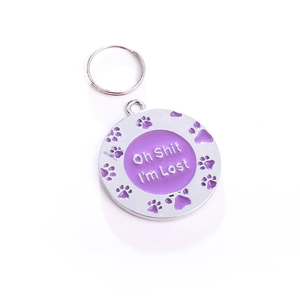 Gros plan d'une médaille violette pour chien avec pattes et gravure humoristique