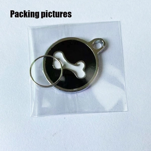 Detail view of round black pet ID tag with white bone pattern in plastic packaging