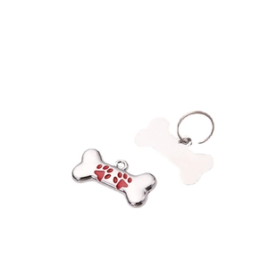 Polished silver bone-shaped dog ID tag with three red paw prints on a white background