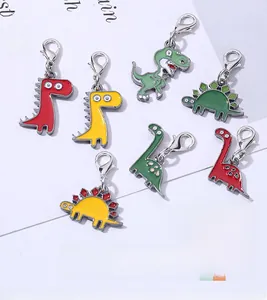 Flat lay of colorful metal dinosaur pendants with lobster clasps for keychains