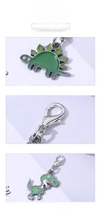 Detail of green enamel cartoon dinosaur metal keychains with silver lobster clasps