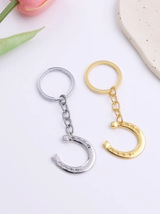 Detailed view of lucky horseshoe keychains in polished gold and silver metal finishes