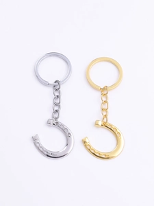 Detailed view of horse shoe keychains in polished gold and silver metal finishes