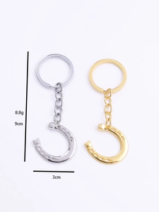 Detail showing gold and silver horseshoe keychains with 9cm length and 3cm width specs