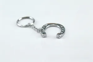 Macro detail of the silver horseshoe keychain showing the metal link and horseshoe charm