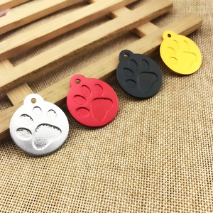 Detailed view of colorful round paw print pet ID tags on a rustic wooden background
