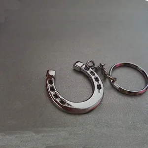 Detailed macro view of silver horseshoe metal keychain with link chain and split ring