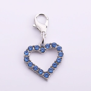 Detail of silver heart-shaped pet collar pendant with sparkling blue rhinestones and clasp