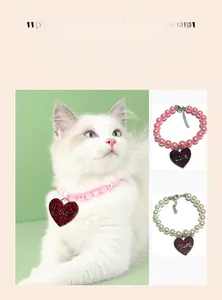 Detail of adjustable pet pearl collar with red glitter heart pendant and Love engraving