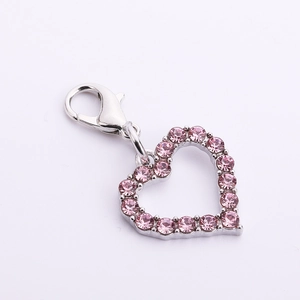 Detail view of heart-shaped pet pendant with pink rhinestones and silver lobster clasp
