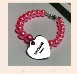 Close-up of pink pet pearl necklace with a customizable heart-shaped metal ID tag