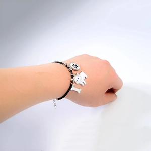 Detail van de geweven huisdier armband met hangers van bulldog bot en pootafdruk