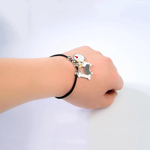 Detail van geweven armband met I Love Dogs bedeltje en hondenhanger van corgi