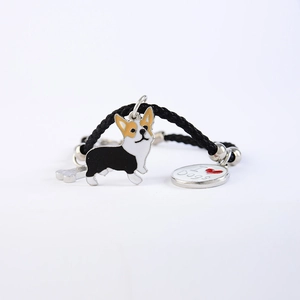 Detail van geweven armband met Corgi-bedeltje, zilveren bot en I Love Dogs-hanger