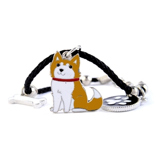 Detailopname van een geweven hondenarmband met emaille hangers van bot en pootafdruk
