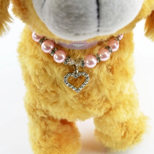 Close-up of pink pet pearl necklace with sparkling heart pendant and rhinestone spacers