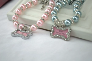Detail of pink and blue pet pearl necklaces featuring rhinestone bone photo frame pendants