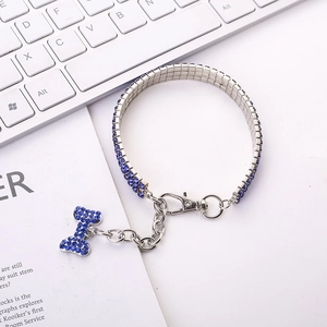 Detail of blue rhinestone pet necklace with bone pendant on a clean white keyboard