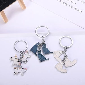 Detailed view of three enamel cat keychains with colorful charms and alloy metal rings