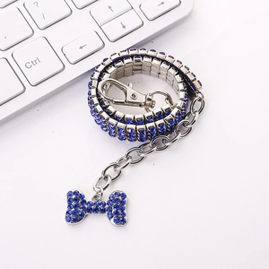 Detailed view of silver pet necklace featuring blue rhinestones and a bow pendant
