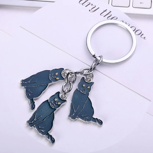 Cute metal cat keychain with three dark grey enamel pendants and yellow eyes on a key ring