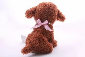 Detail view of brown plush dog featuring a pink checkered bow and pearl necklace