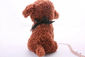 Detail view of brown curly plush poodle toy with black satin bow and pearl bead chain