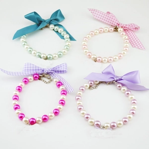 Detail showing four colors of pearl pet collars with ribbon bows and lobster clasps