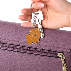 Orange cartoon Chow Chow enamel keychain with I Heart Dogs tag on purple leather bag